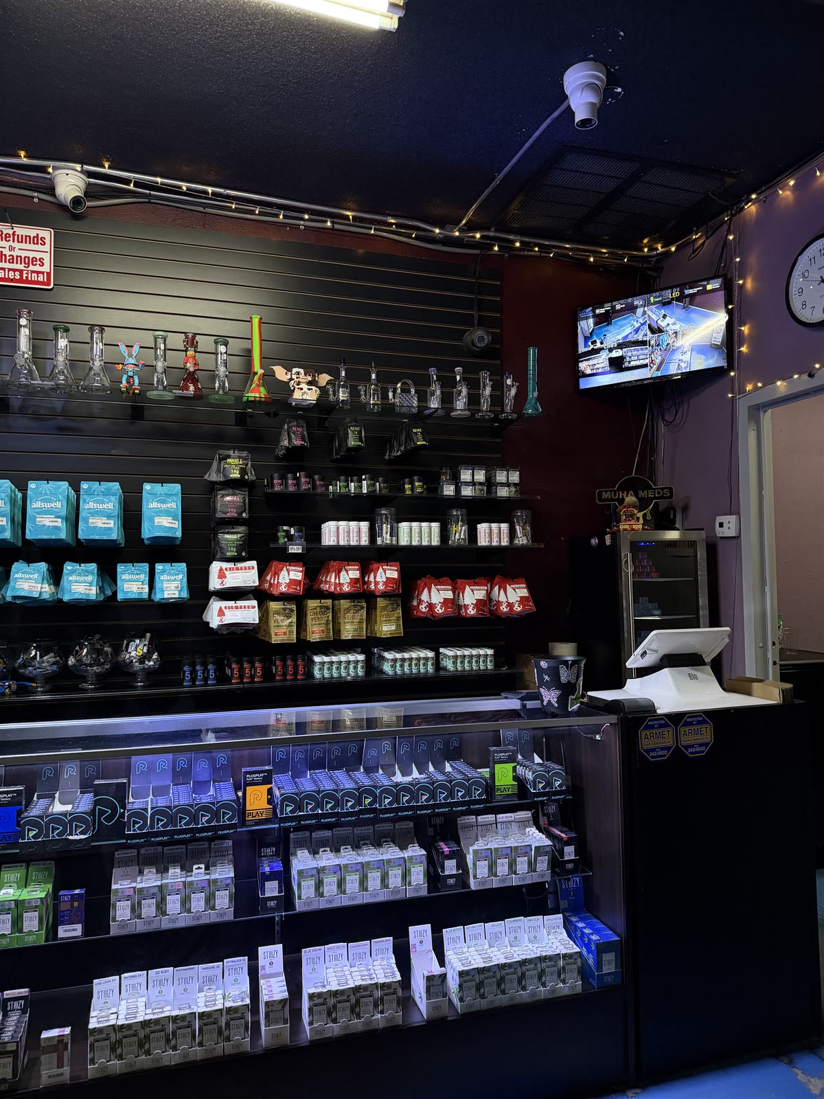 Glass display cases inside Central Remedies, lit and stocked, on the dark shop floor.