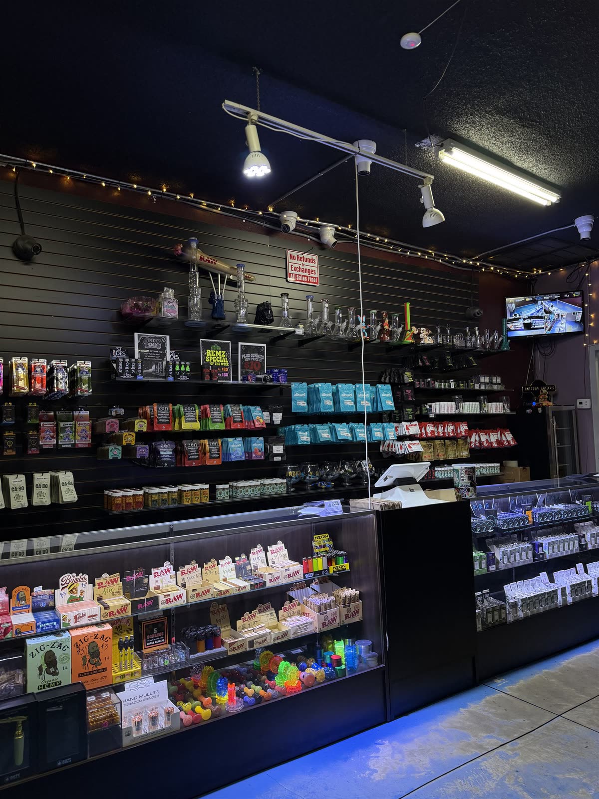 Inside Central Remedies — slat-wall shelves of packaged products, glass display counters, and track lighting over the shop floor.